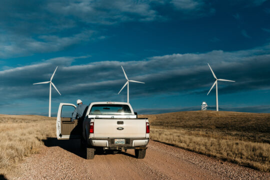 Commercial truck with wind turbines in the background