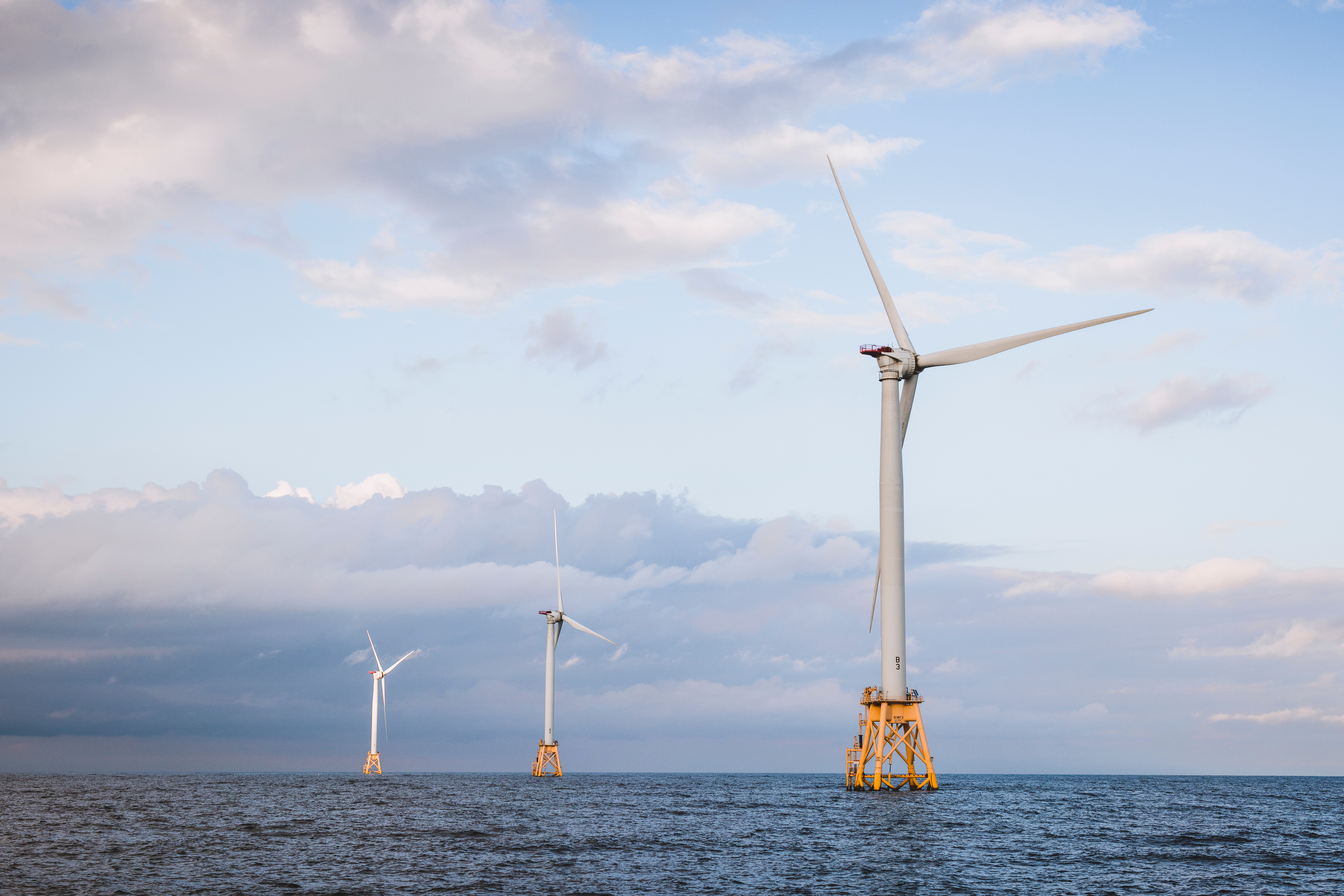 Three offshore wind turbines at dusk